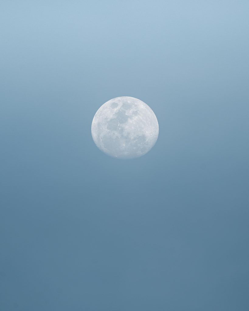 pexels-photo-5707732-5707732 Full white round moon with craters on surface shining on cloudless clear sky in nature on summer day high in air